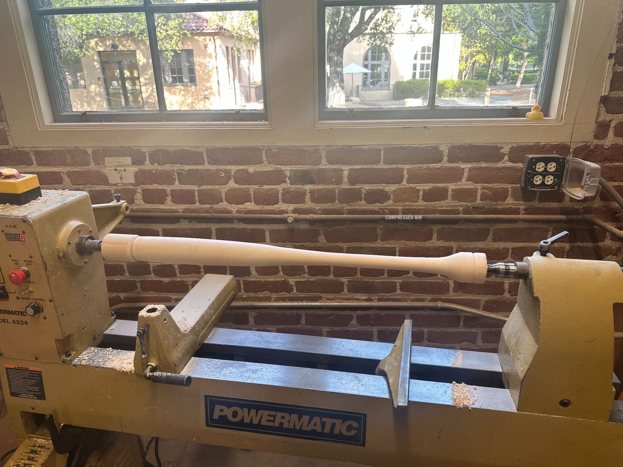 Wooden baseball bat being shaped on a lathe